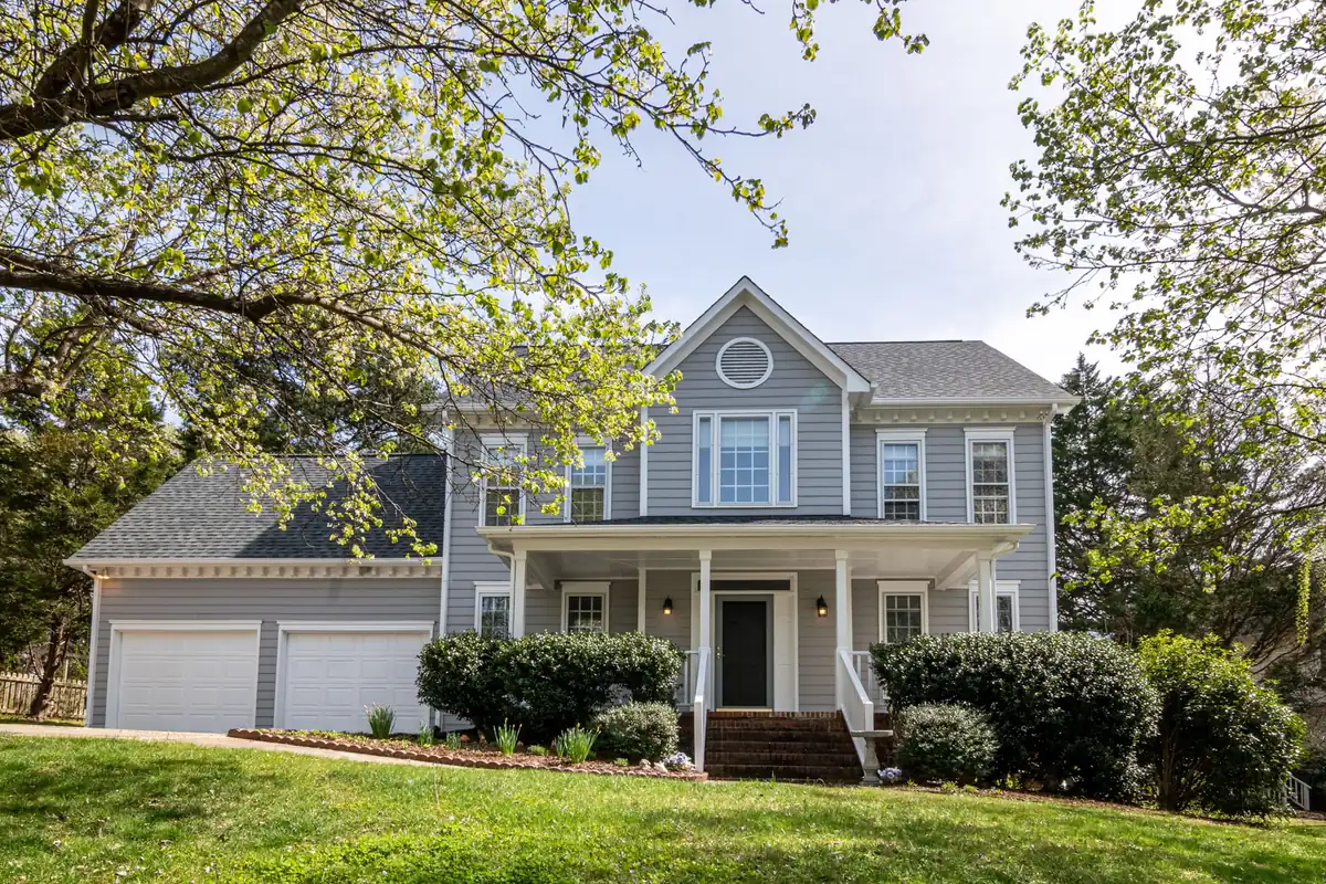 Gray two-story colonial with a covered front porch and attached two-car garage