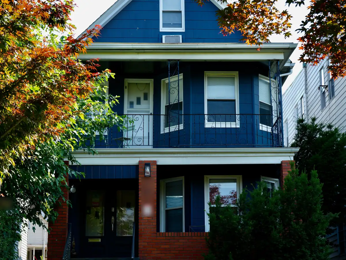 Blue two-family house with stacked front porches, one unit on each floor